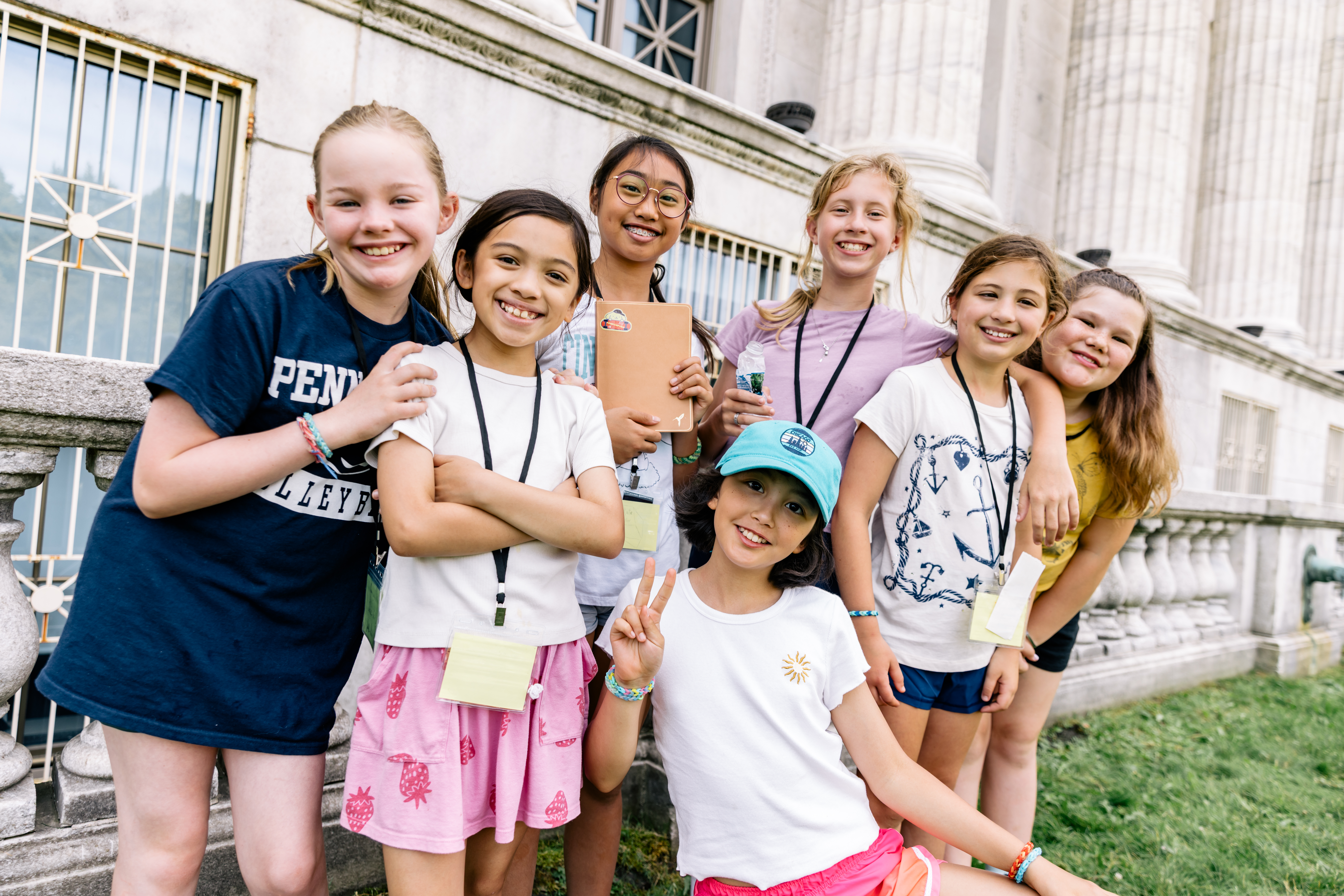 A group of students stand together on an outdoor terrace next to the Museum