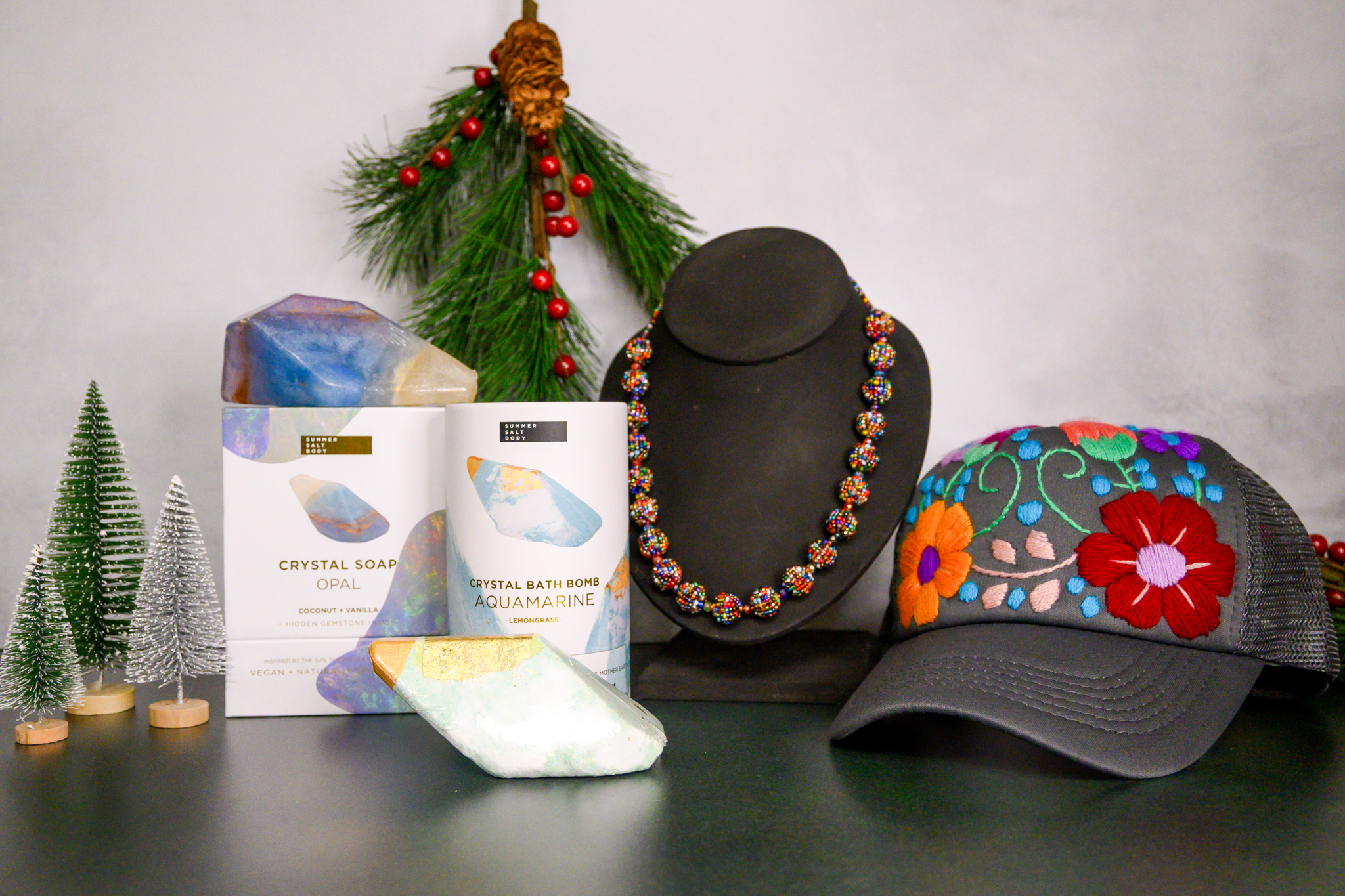 An array of items from the Field store, including an embroidered cap, crystal soap and bath bomb, and beaded necklace