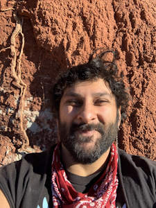 Arjan Mann standing in front of a red rock wall
