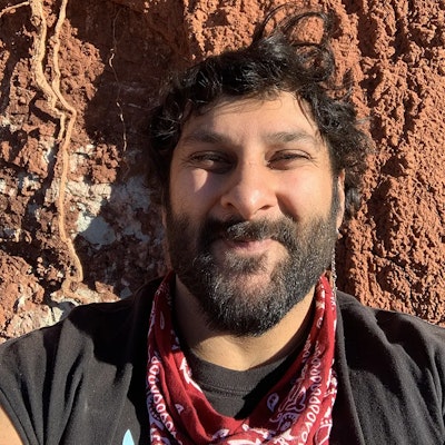 Arjan Mann standing in front of a red rock wall