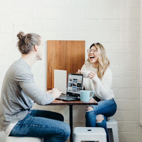two people laughing together at work