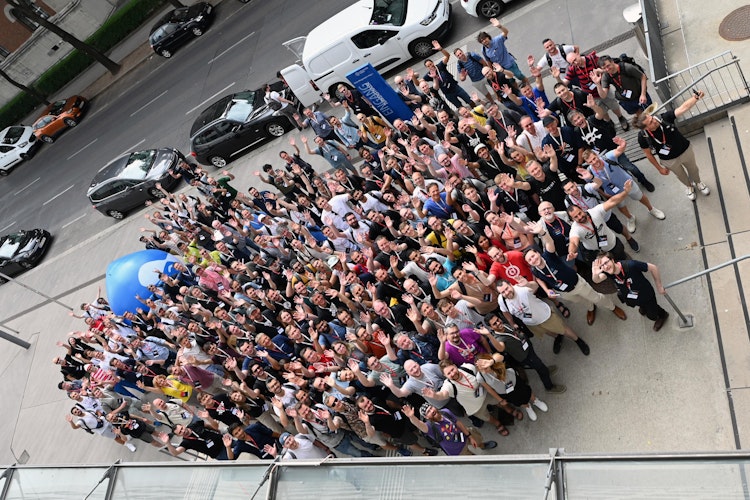a bird's-eye-view image of the attendees from Drupal Dev Days 2023 wvaing to the camera