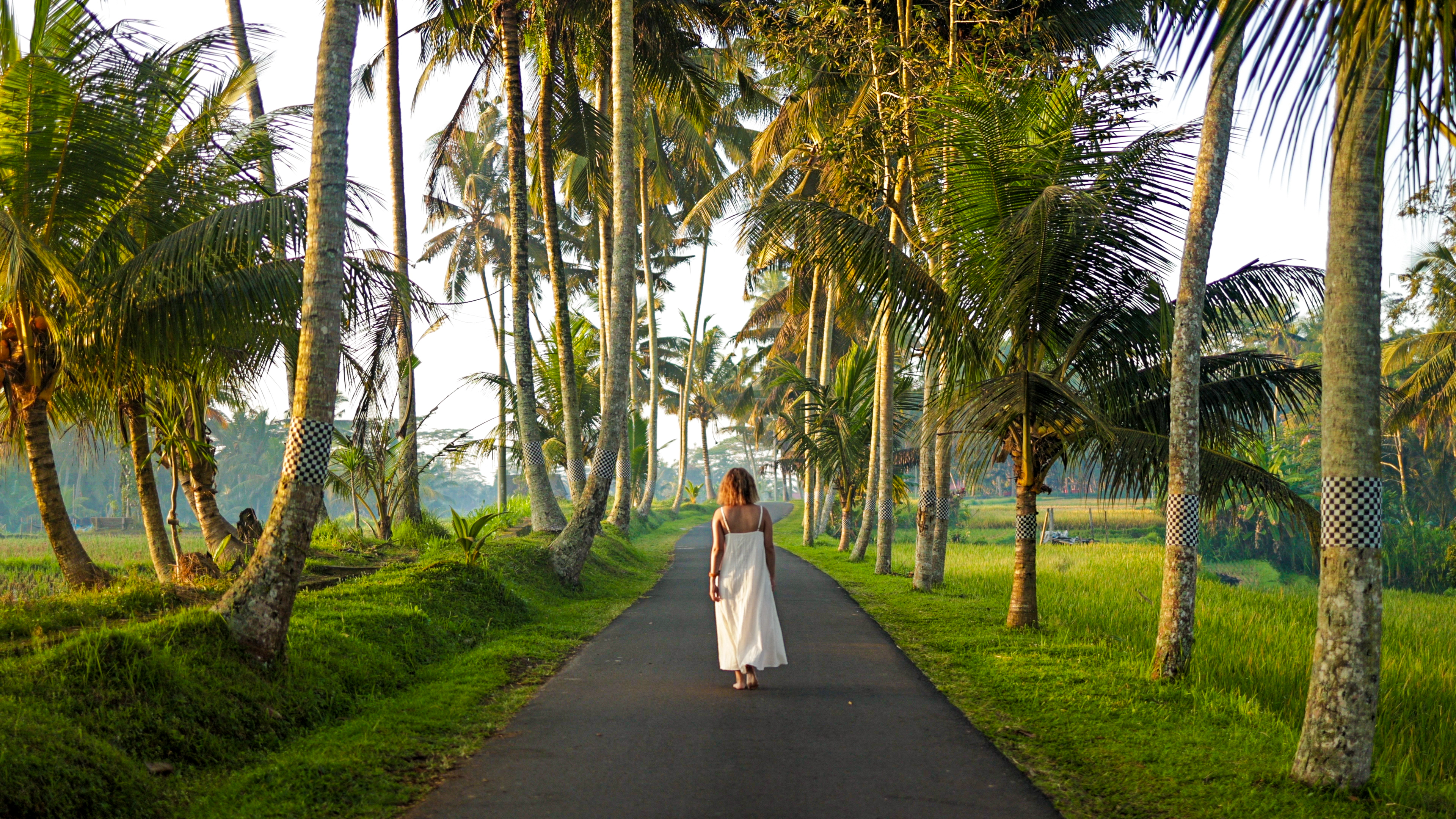 Woman walking through trees in Bali