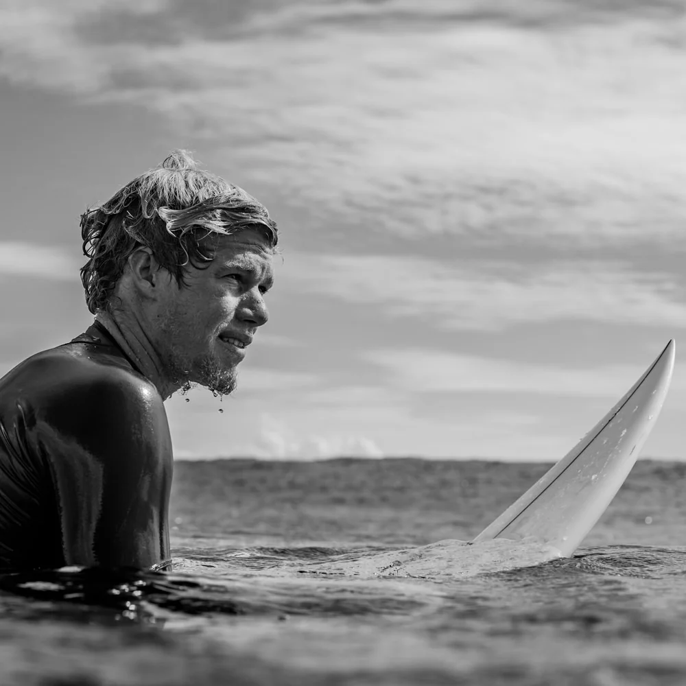 Surfer in the ocean holding a surfboard