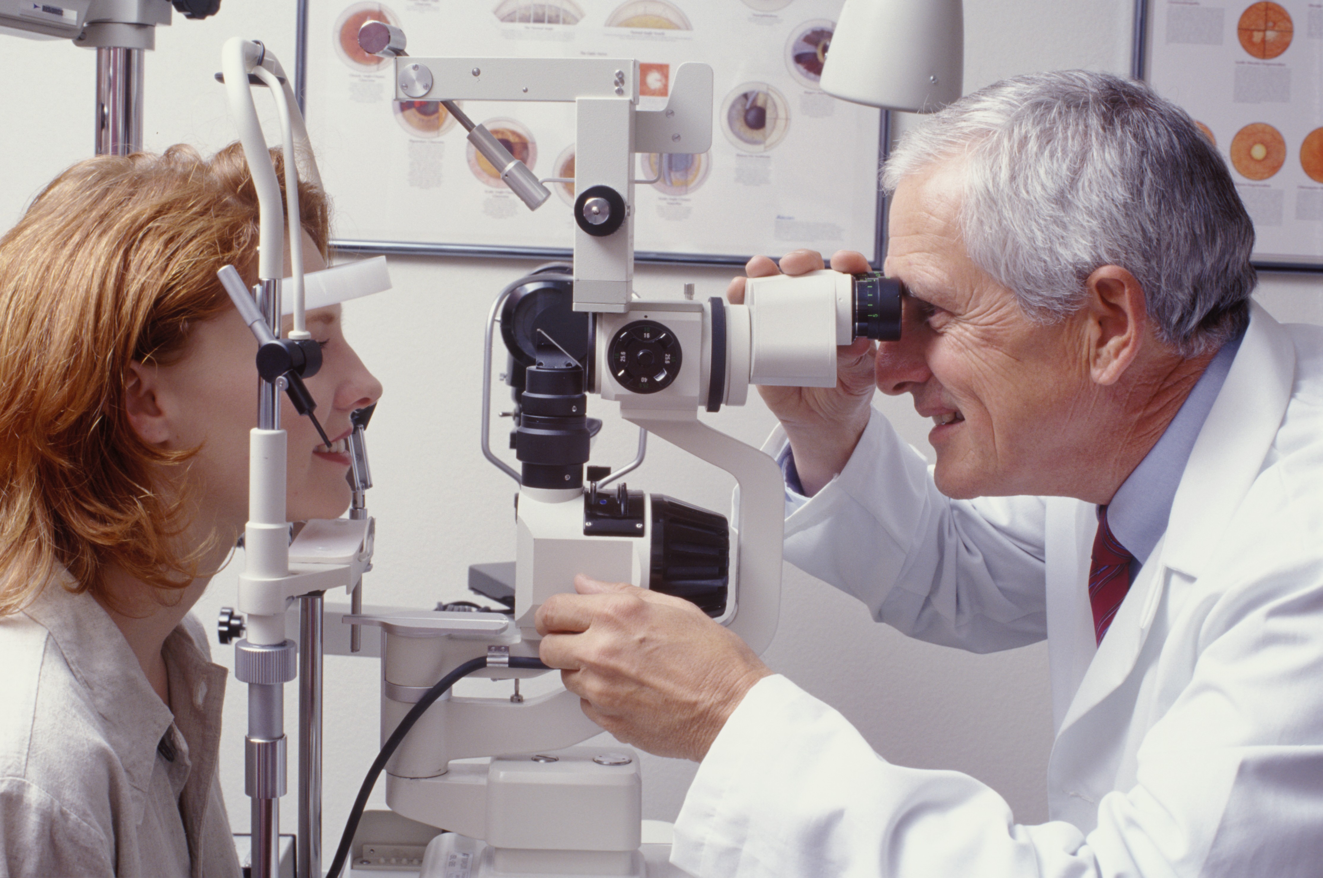 Optometrist performing an eye test with a patient