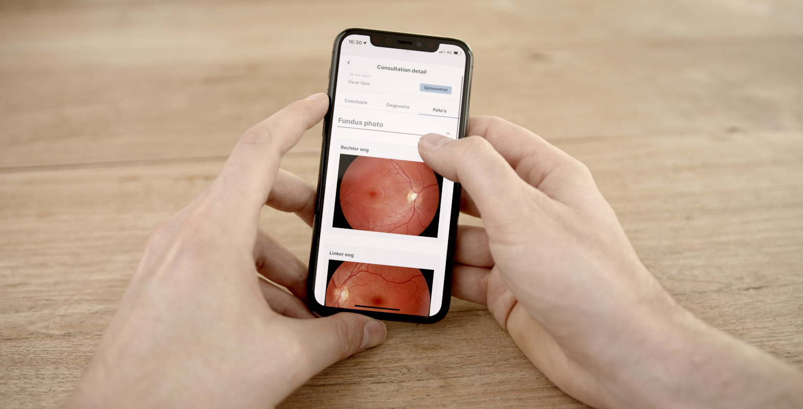 Hands holding an iPhone with the Eyehelp Patient app active.