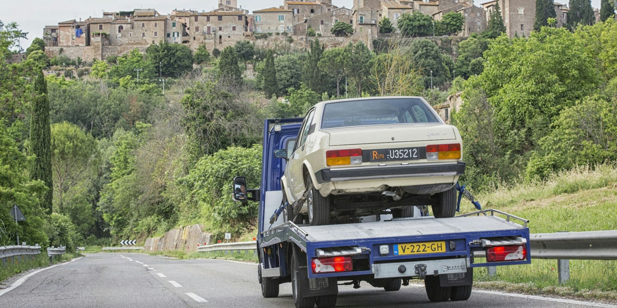 Mercedes autotransporter met auto op weg in Italië.