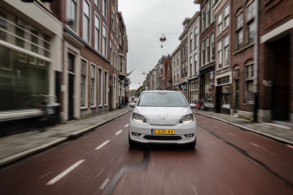 Witte Skoda Citigo-e IV van DIKS autoverhuur op de weg in Amsterdam.