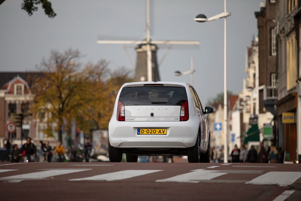 Witte Skoda Citigo-e IV van DIKS autoverhuur op de weg in Amsterdam Oost.