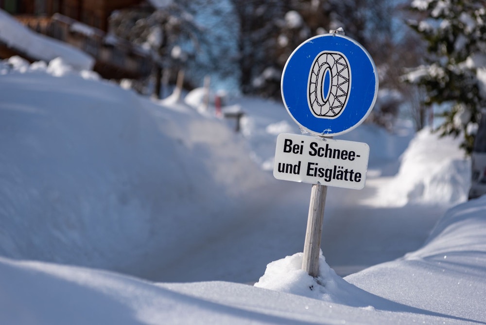 Sneeuwkettingen verplicht bij sneeuw en ijs blauw verkeersbord in de sneeuw.