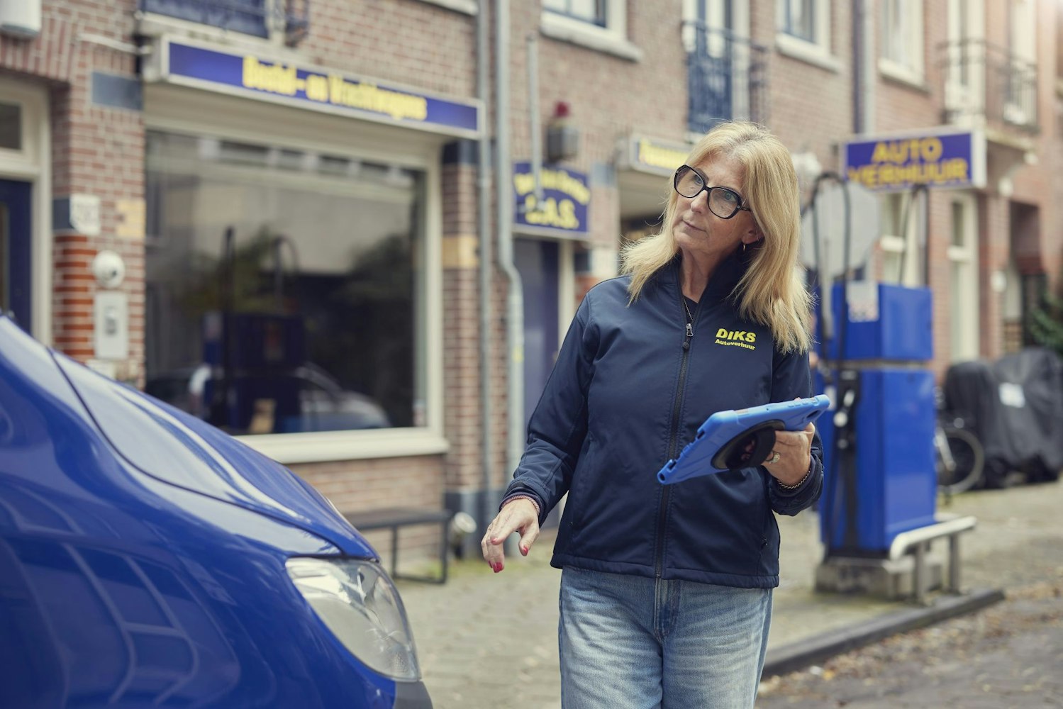 DIKS medewerkster controleert buiten een voertuig met behulp van een tablet.