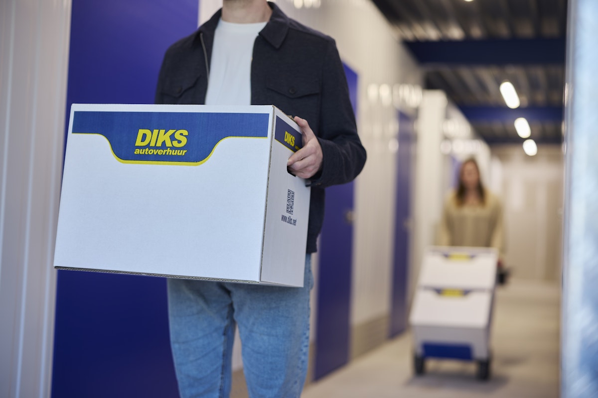 Mensen met verhuisdozen in opslagruimte