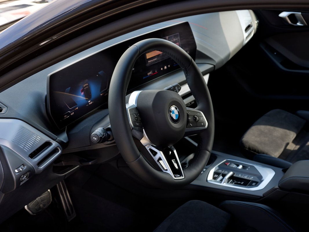Interior of a BMW passenger car with digital dashboard and sports steering wheel, suitable for short-term lease at DIKS