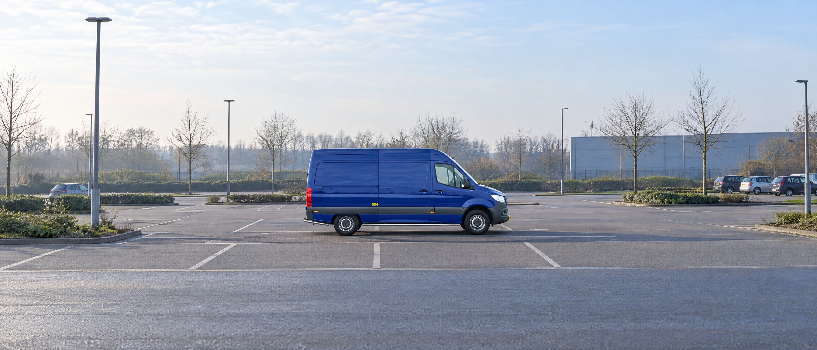 DIKS blauwe Mercedes-Benz Sprinter bestelbus geparkeerd op lege parkeerplaats