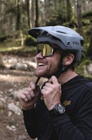mountain biker in helmet wearing SunGod sunglasses to hit the trails