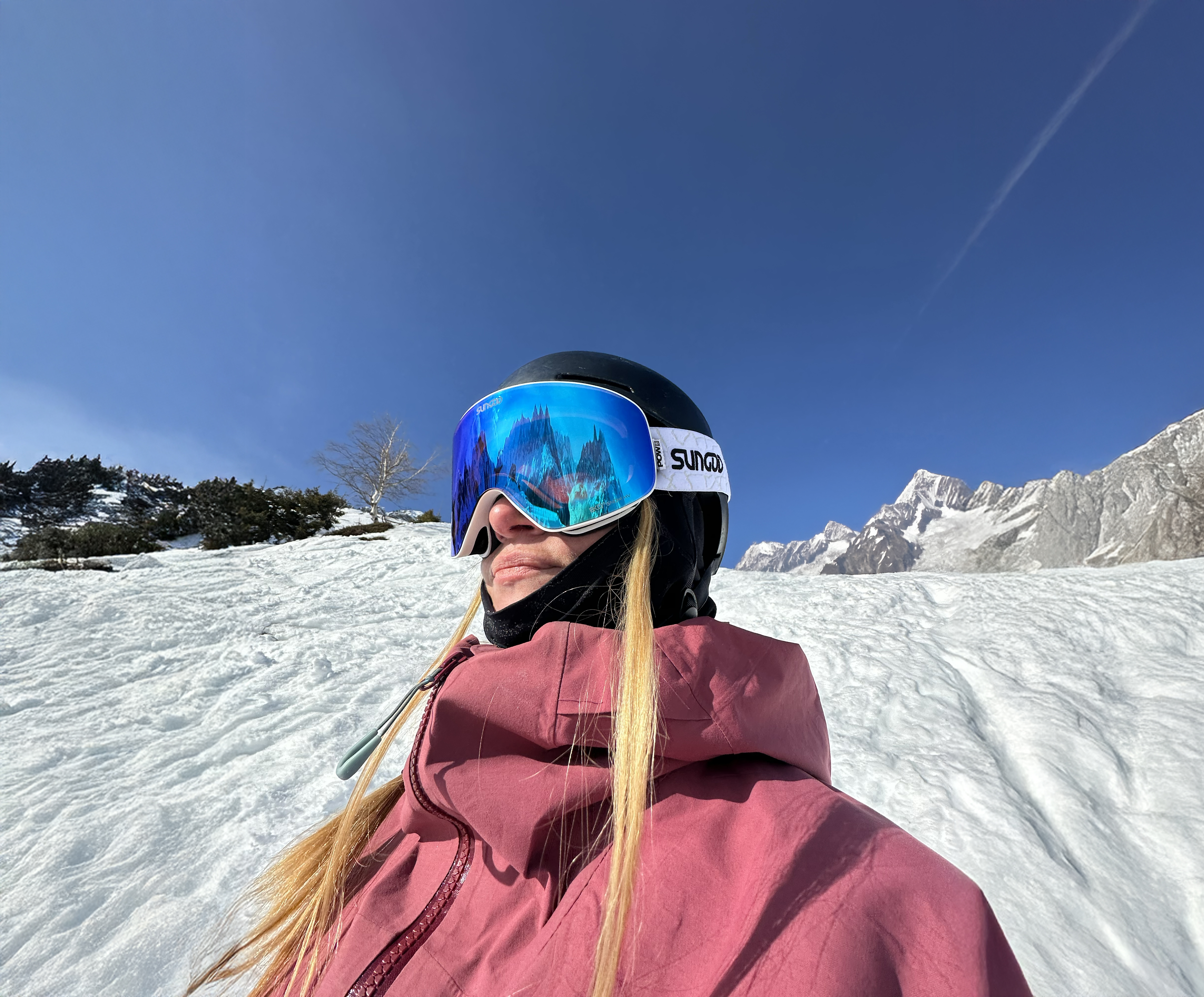 Woman wearing SunGod goggles in front of mountains