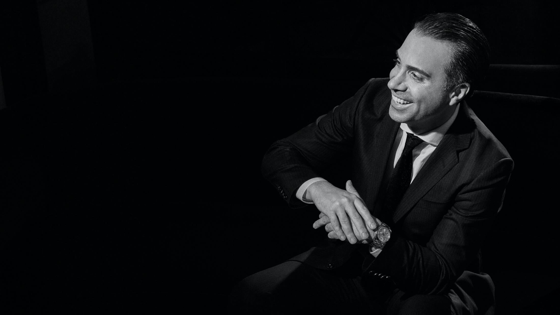 Dr. Hovsepian smiling in a chair in black and white