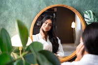 young lady looking at mirror reflection