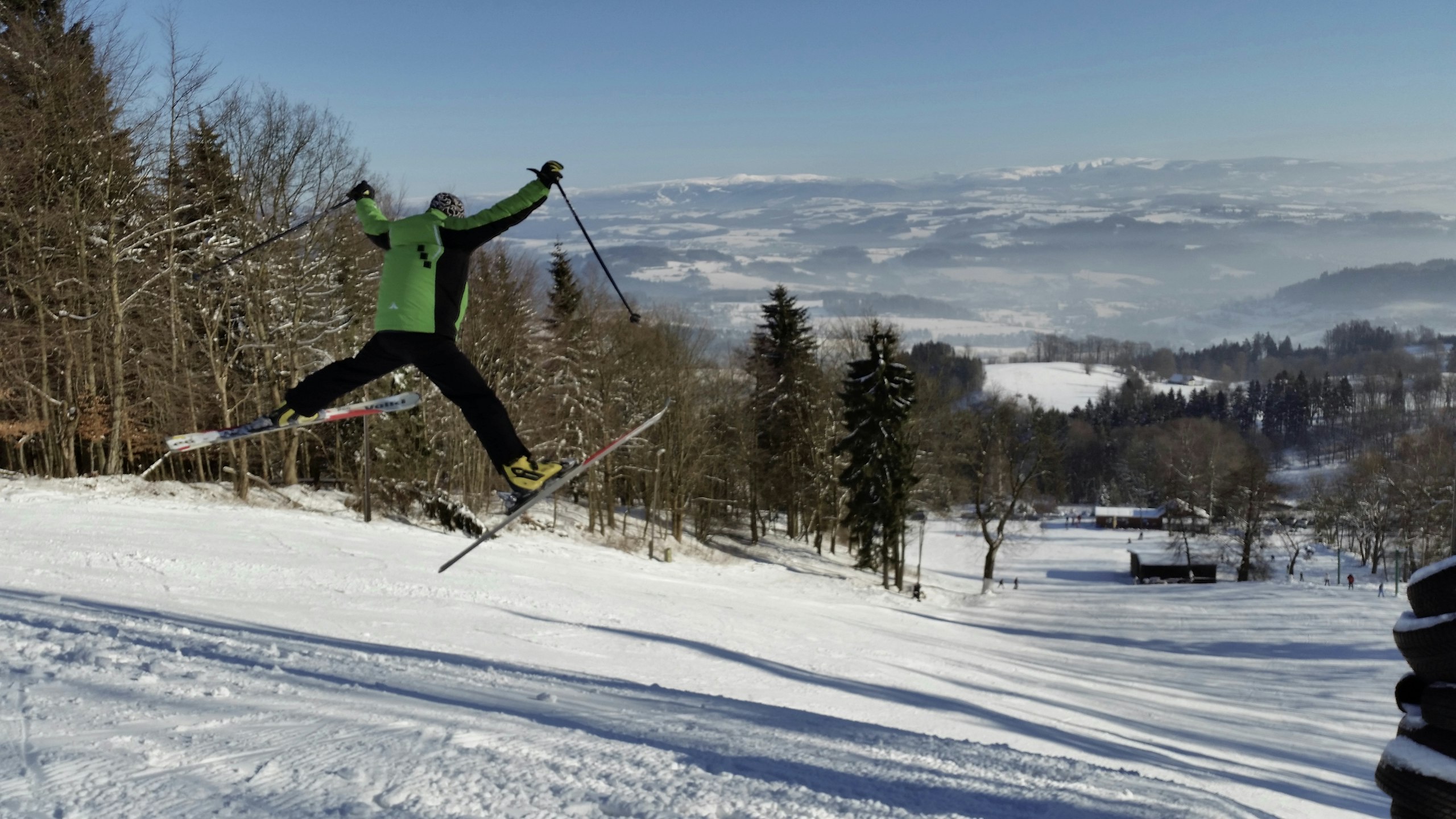 Lyžař ve skoku na sjezdovce v lyžařském areálu Kozákov