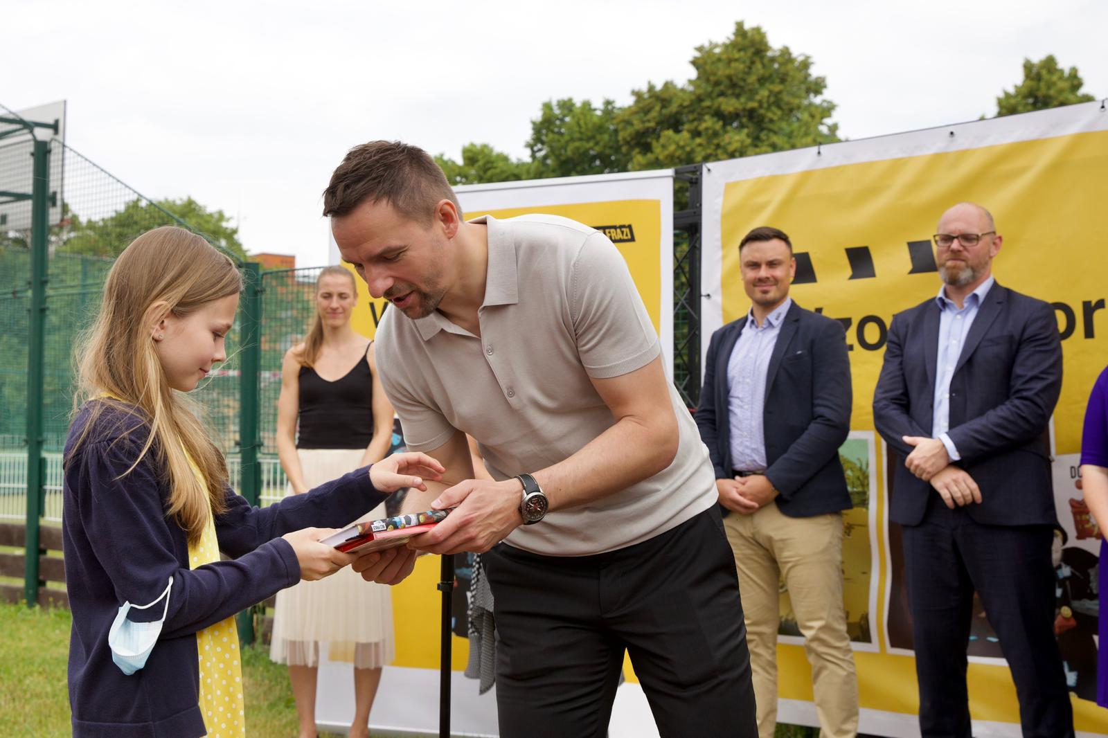 Radim Vrbata předává knihu jedné z oceněných žaček v rámci projektu Vzory vzorům, společného počinu Bez frází a NadacePPF