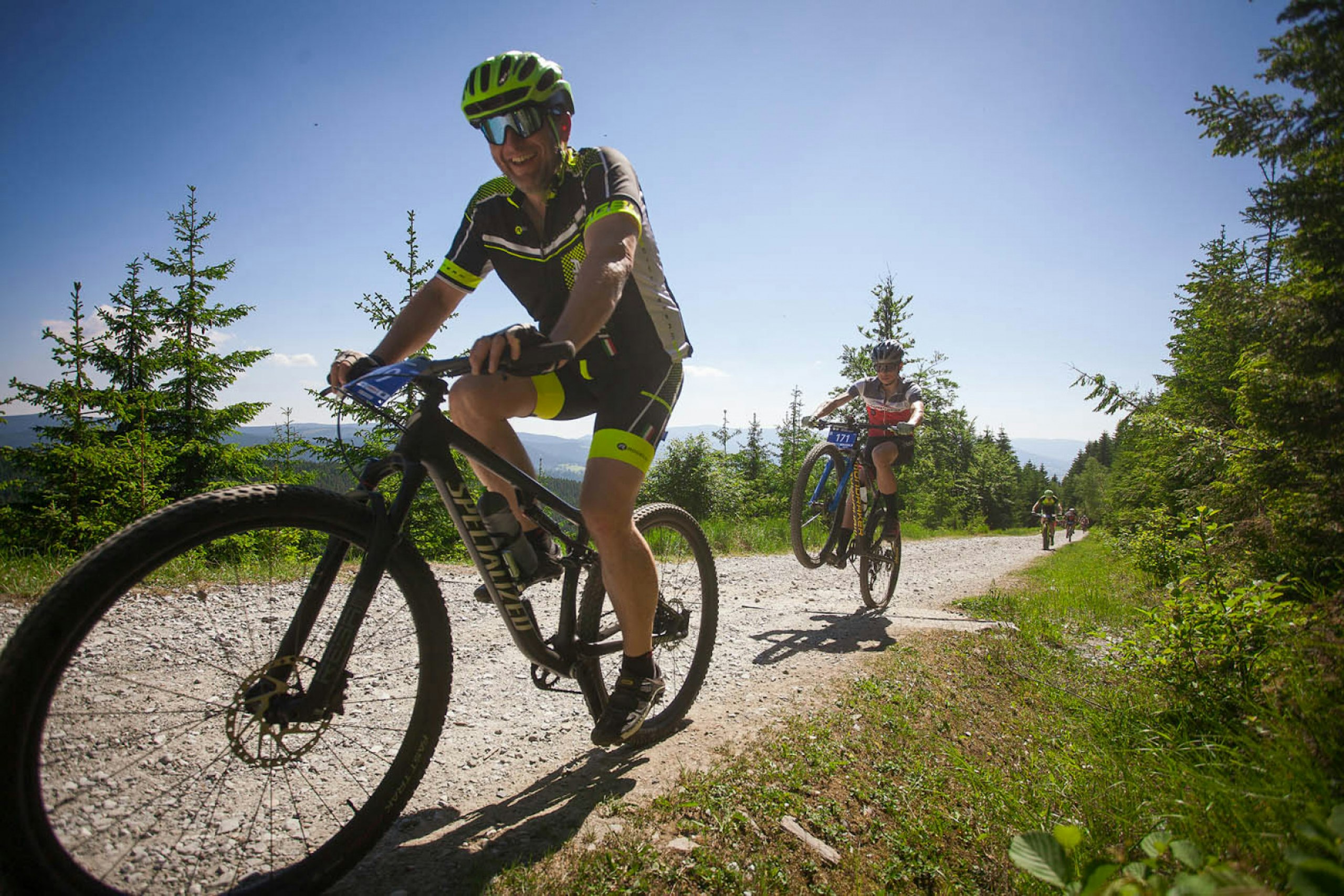 Cyklisté jedou po lesní cestě v horách během závodu Kraličák MTB Tour CARDION ze seriálu Kolo pro život