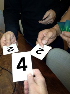 people holding cards with numbers 2 and 4
