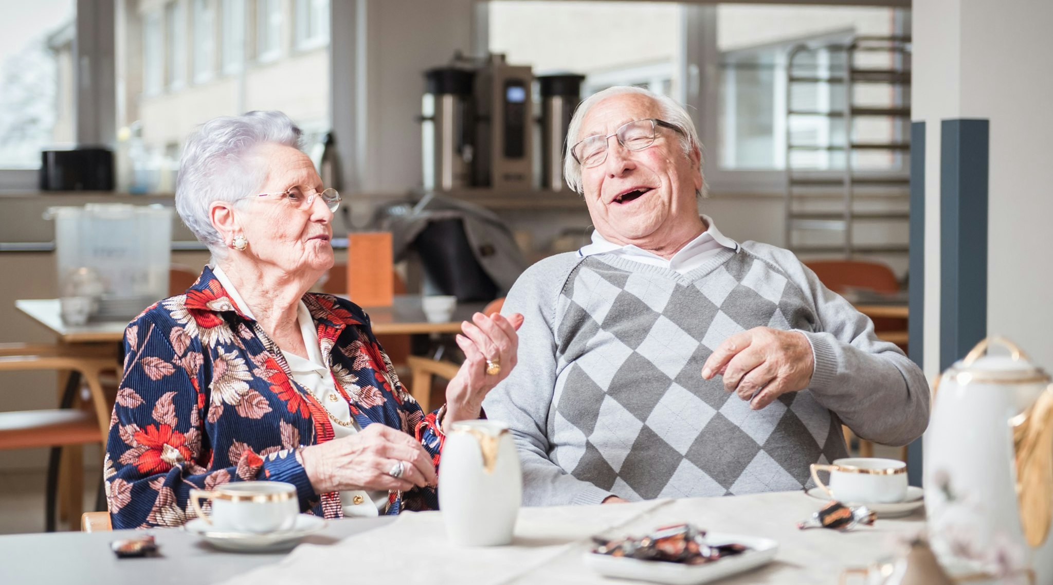 Motena hero image, two elderly people enjoying care in nursery home