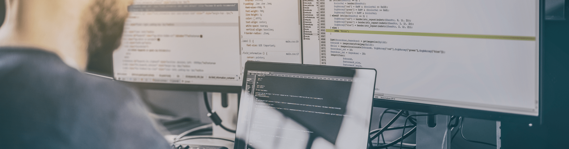 Developer programming in front of computer screens