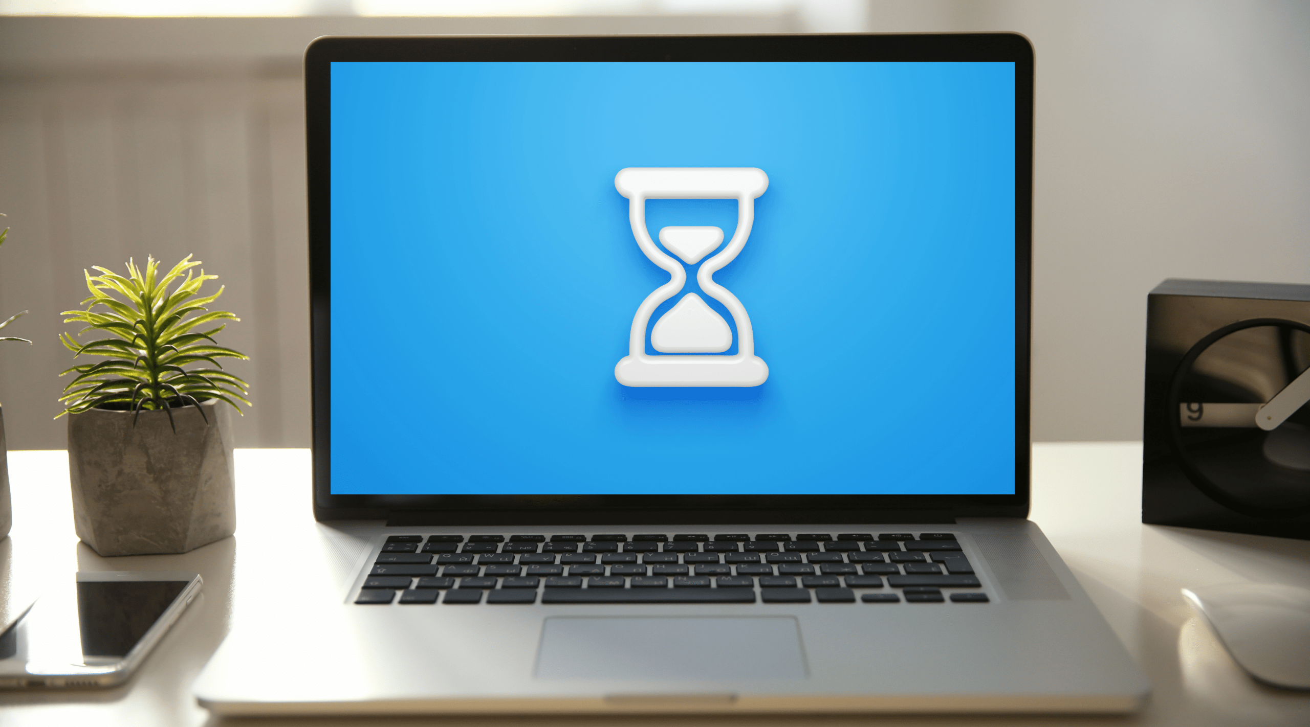Liferay Freemarker Tips and Tricks: Date & Time blog post hero image, laptop screen on desk displaying hourglass