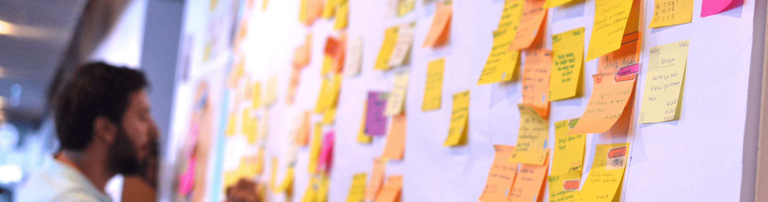 An IT worker tracking his tasks on Kanban board. Using Kanban board for task control is a kind of agile development methodology.