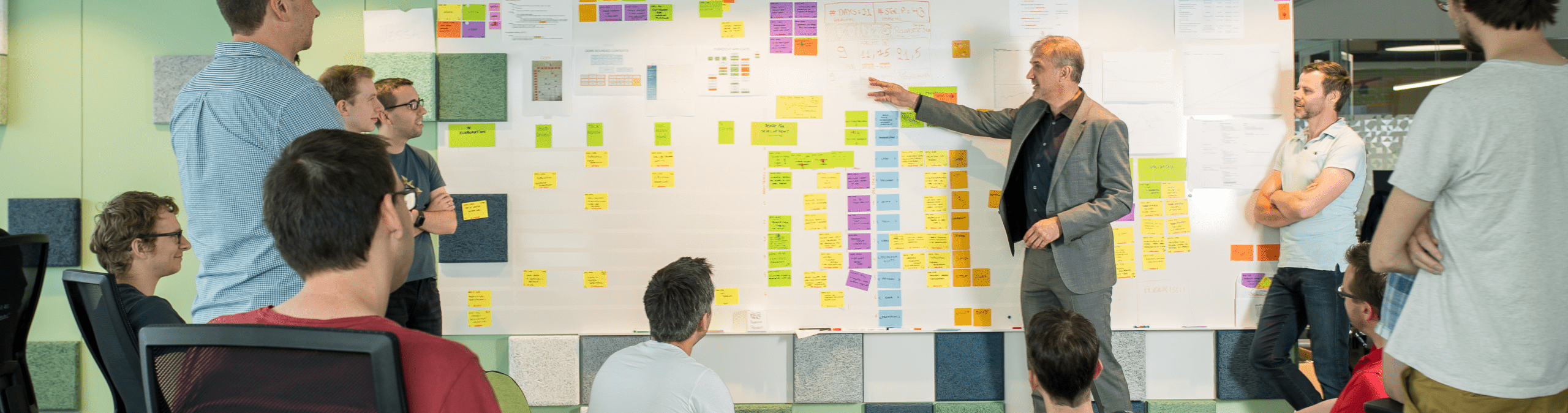 Software developers standing at a Kanban board