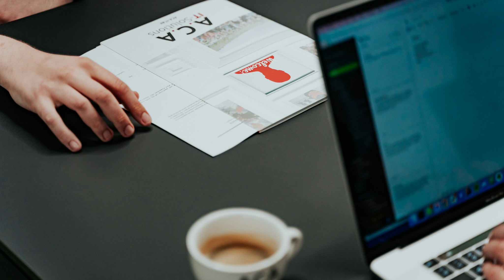 Map with ACA logo, laptop, a cup of coffee
