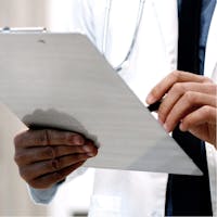 Doctor reading off of a clipboard