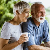 Older couple sitting outside drinking coffee