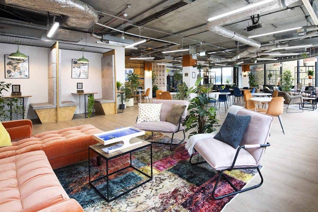 A colourful breakout space in the Runway East Borough Market office with comfy chairs and plants everywhere