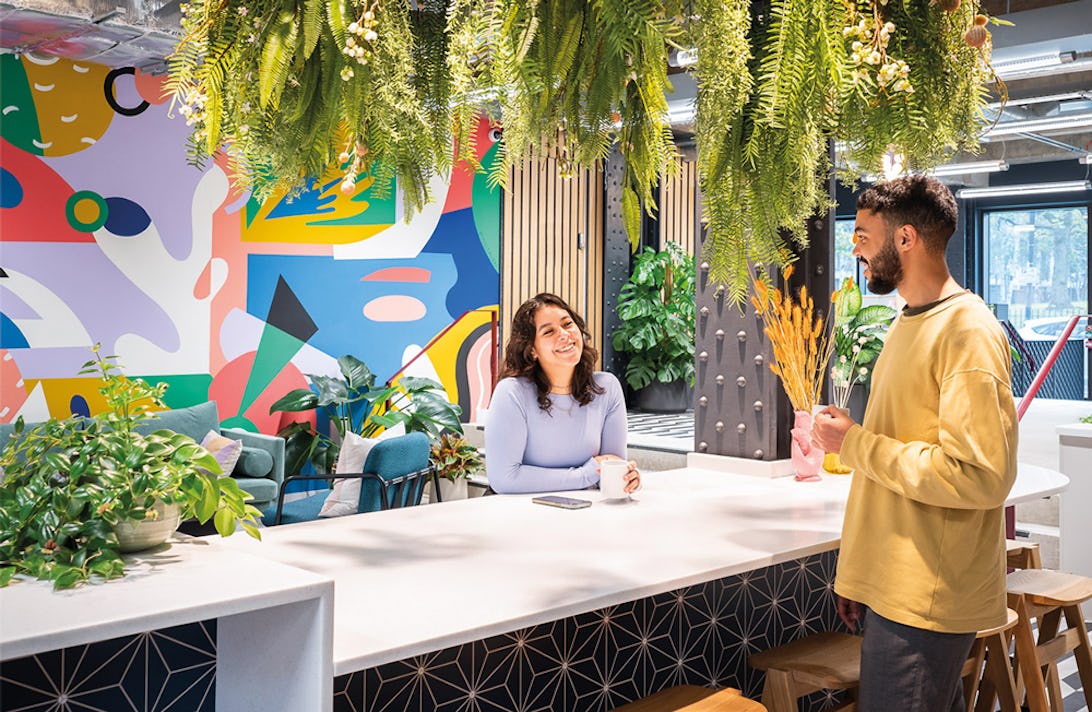 Two people chatting in a communal kitchen at Runway East serviced offices