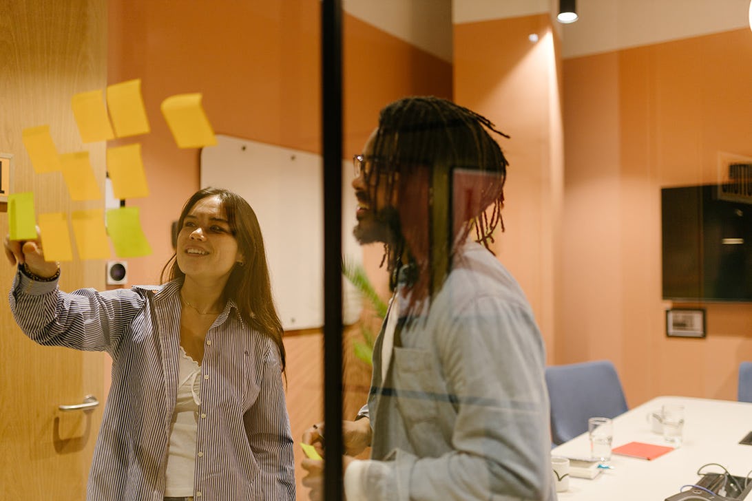 Two people brainstorming in a meeting room at Runway East Birmingham