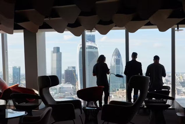 An image of the skyline view of from the shard with silhouettes of people looking at the view