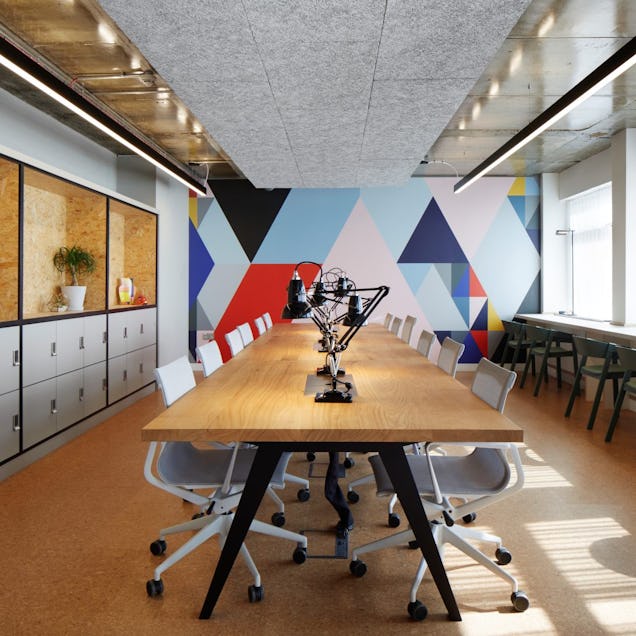 Image of the Alpha Works hot desking area with a geometric mural in the background