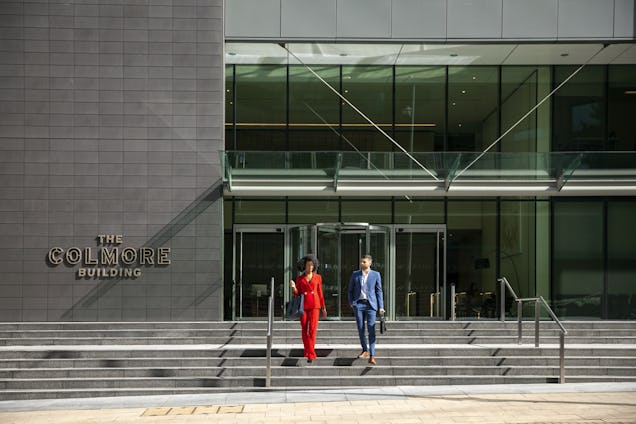 A photo of the outside of the Colmore Building with two people walking down the stairs