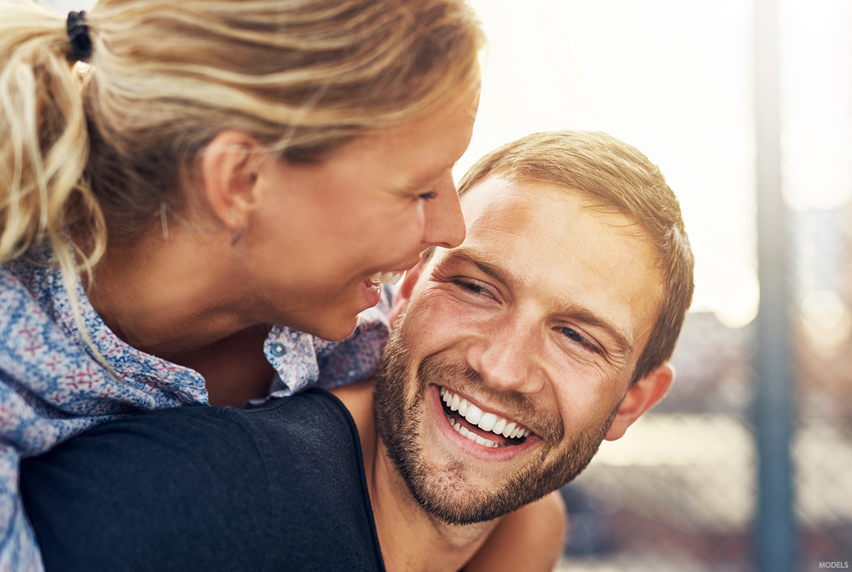 A man looks happy as he is complimented by his girlfriend about his hair.