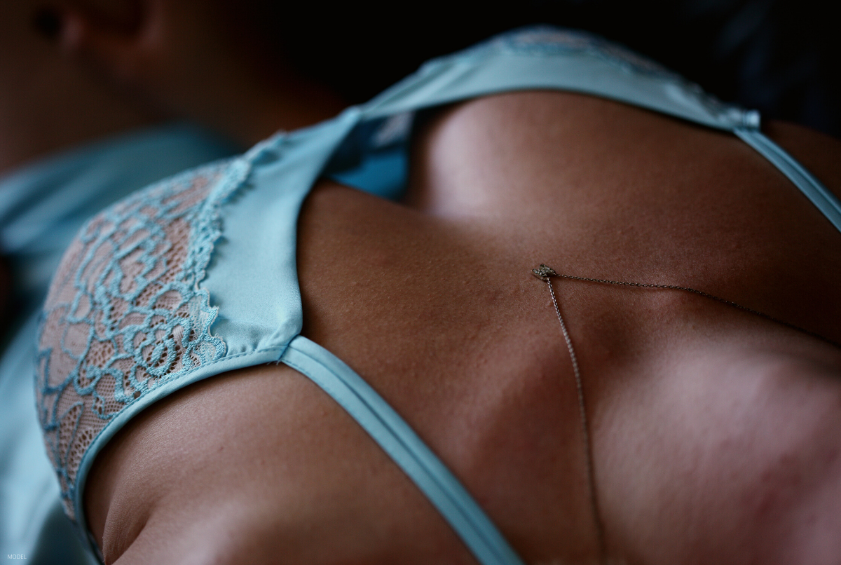 A woman lays down after getting scar-less breast augmentation surgery.