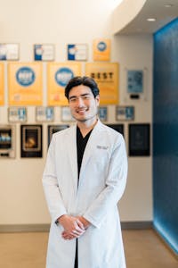 Dr. Zachary Long standing with a white coat on