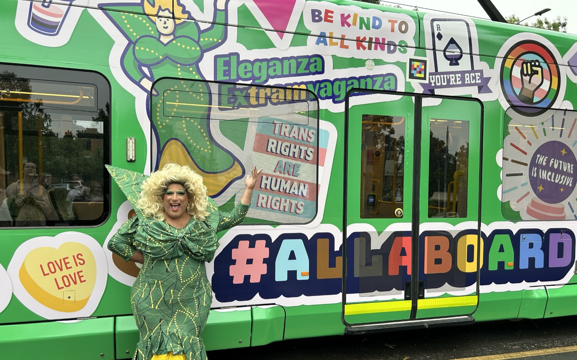 Photo of a drag queen in front of a decorated streetcar on the occasion of the pride in Australia
