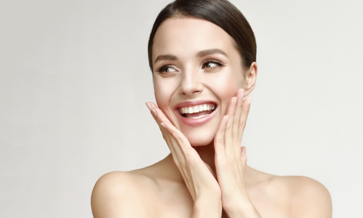 woman smiling while touching her face