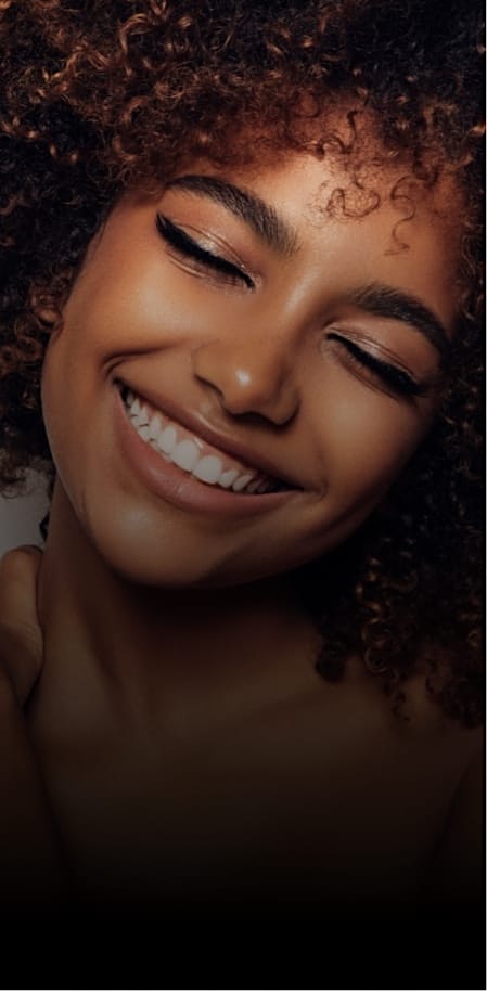 Beautiful woman with curly hair smiling with her eyes closed