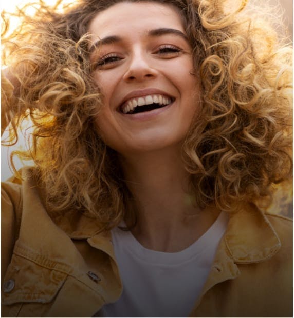 woman with curly blonde hair smiling