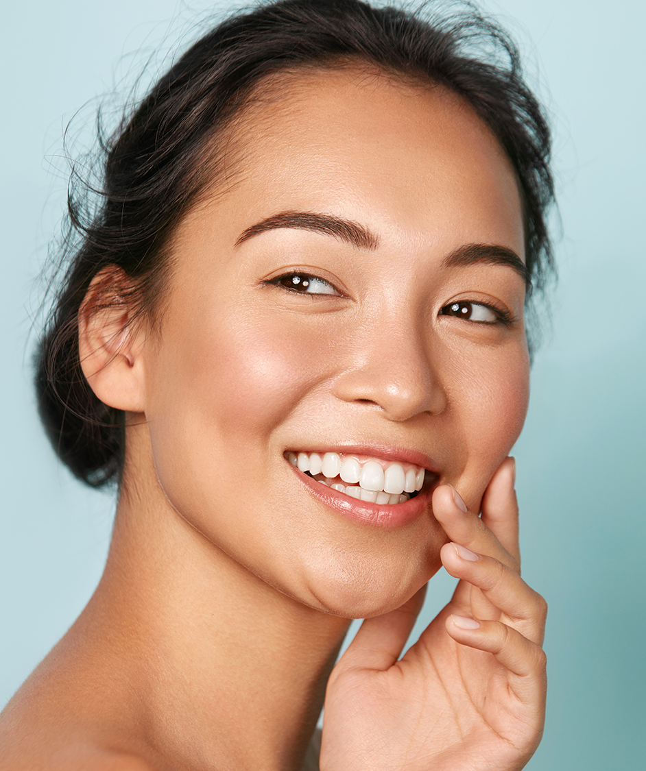 Beautiful woman with clear skin smiling, looking to the side