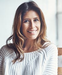 Woman smiling wearing white sweater