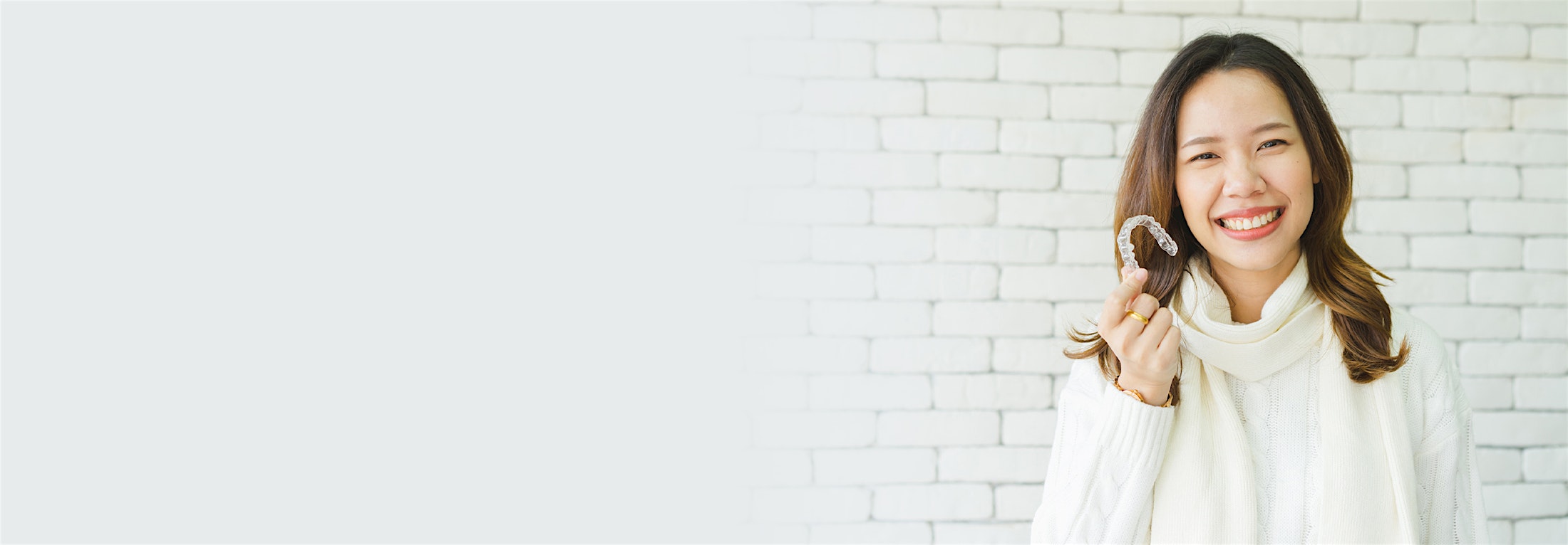 Woman smiling holding her Invisalign